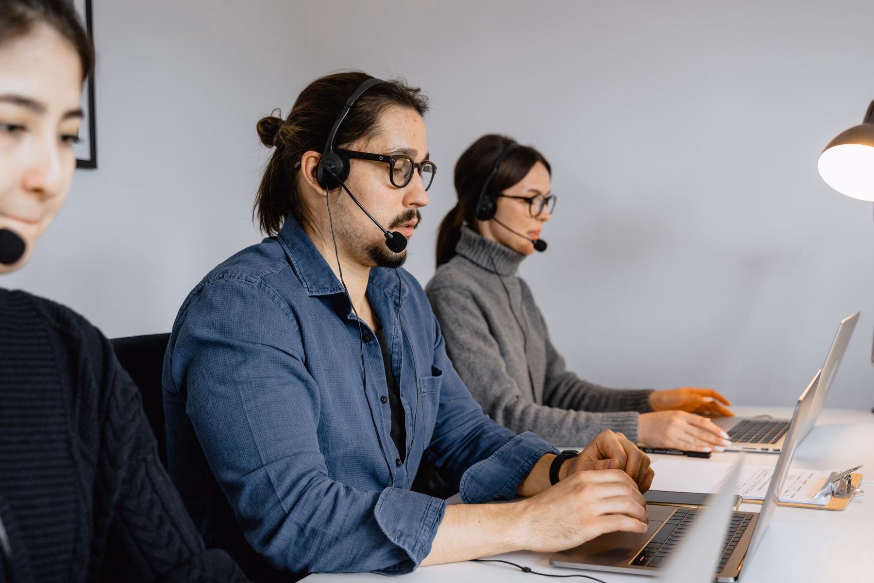 Customer service team using laptops representing AI-assisted website intake and lead routing