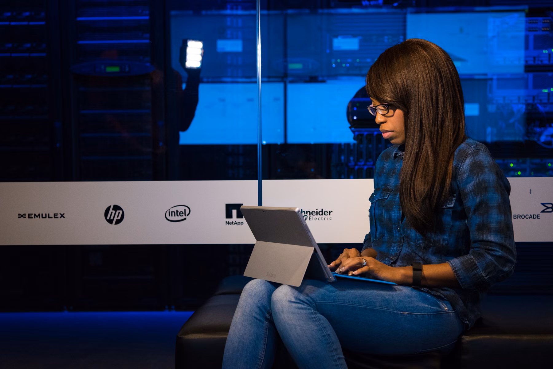 Technology professional working with a laptop in a server room