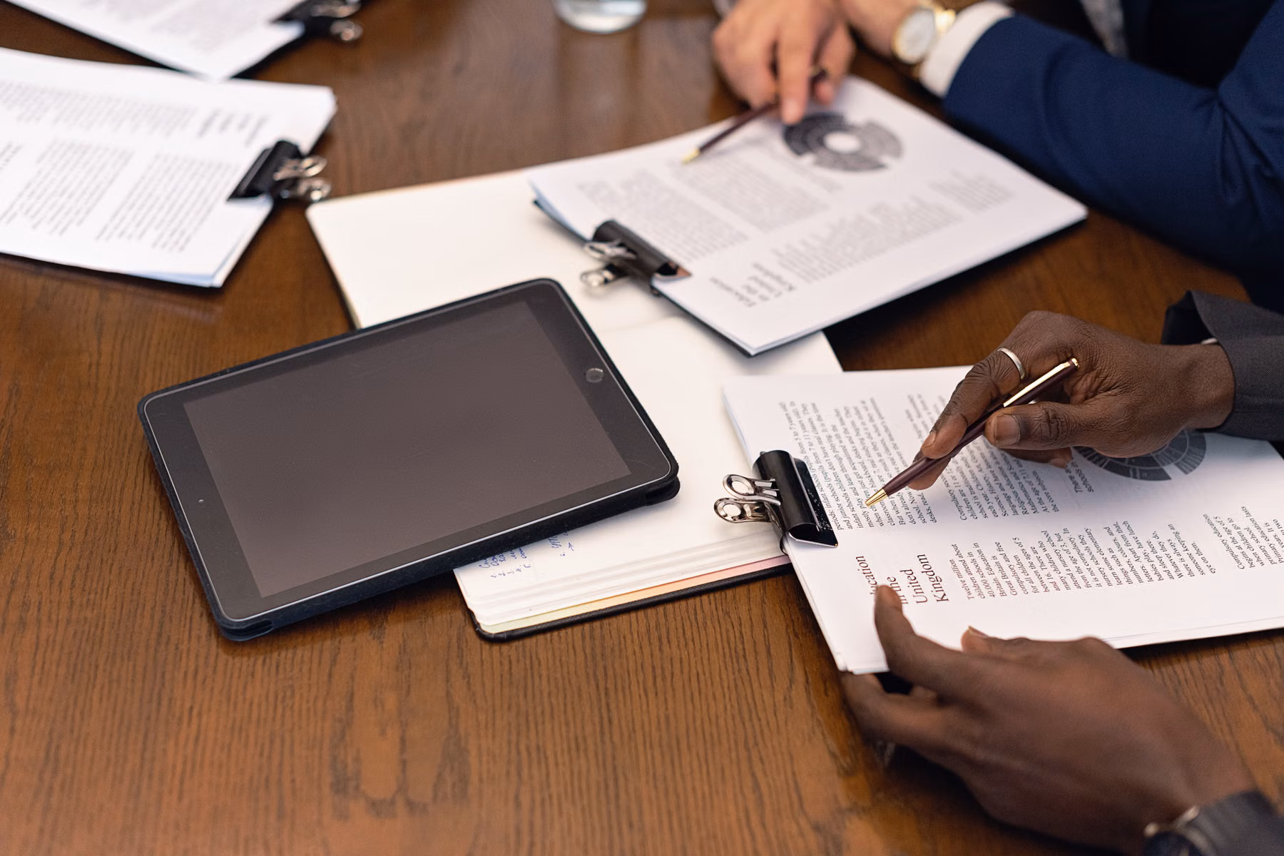 Business professionals reviewing documents and technology decisions together